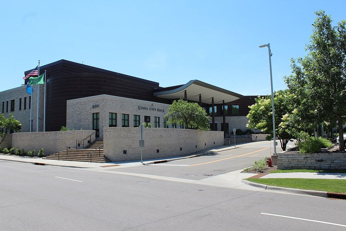 Edina City Hall, a stone and brick building with flags out front